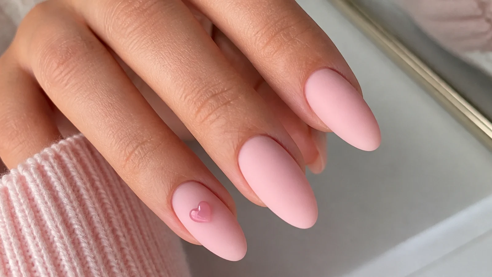 Soft pink matte nails with a small glossy pink heart accent
