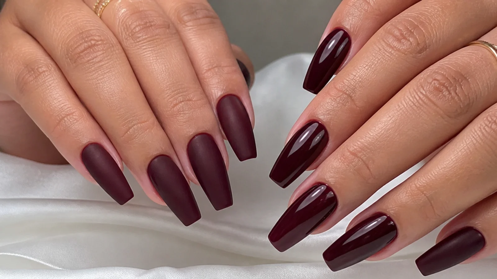 Matte burgundy nails beside glossy oxblood nails on a coffin shape