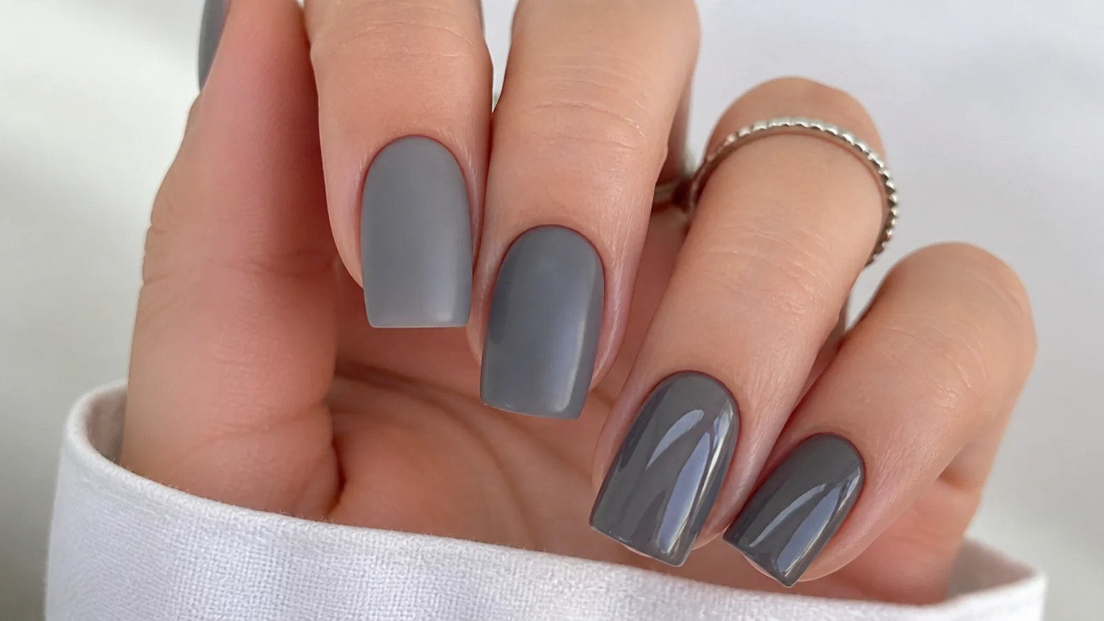 Matte gray nails beside glossy gray nails on a squoval shape