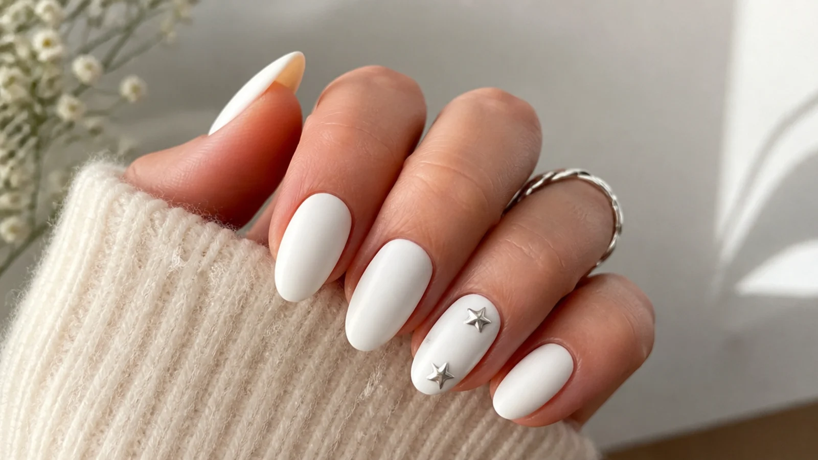 Matte white nails with small silver star studs on an accent nail