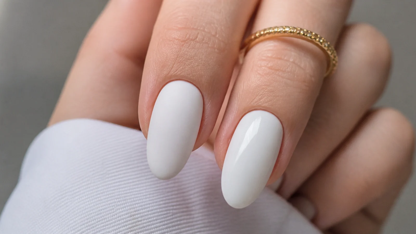 One matte white nail beside one glossy white nail for comparison