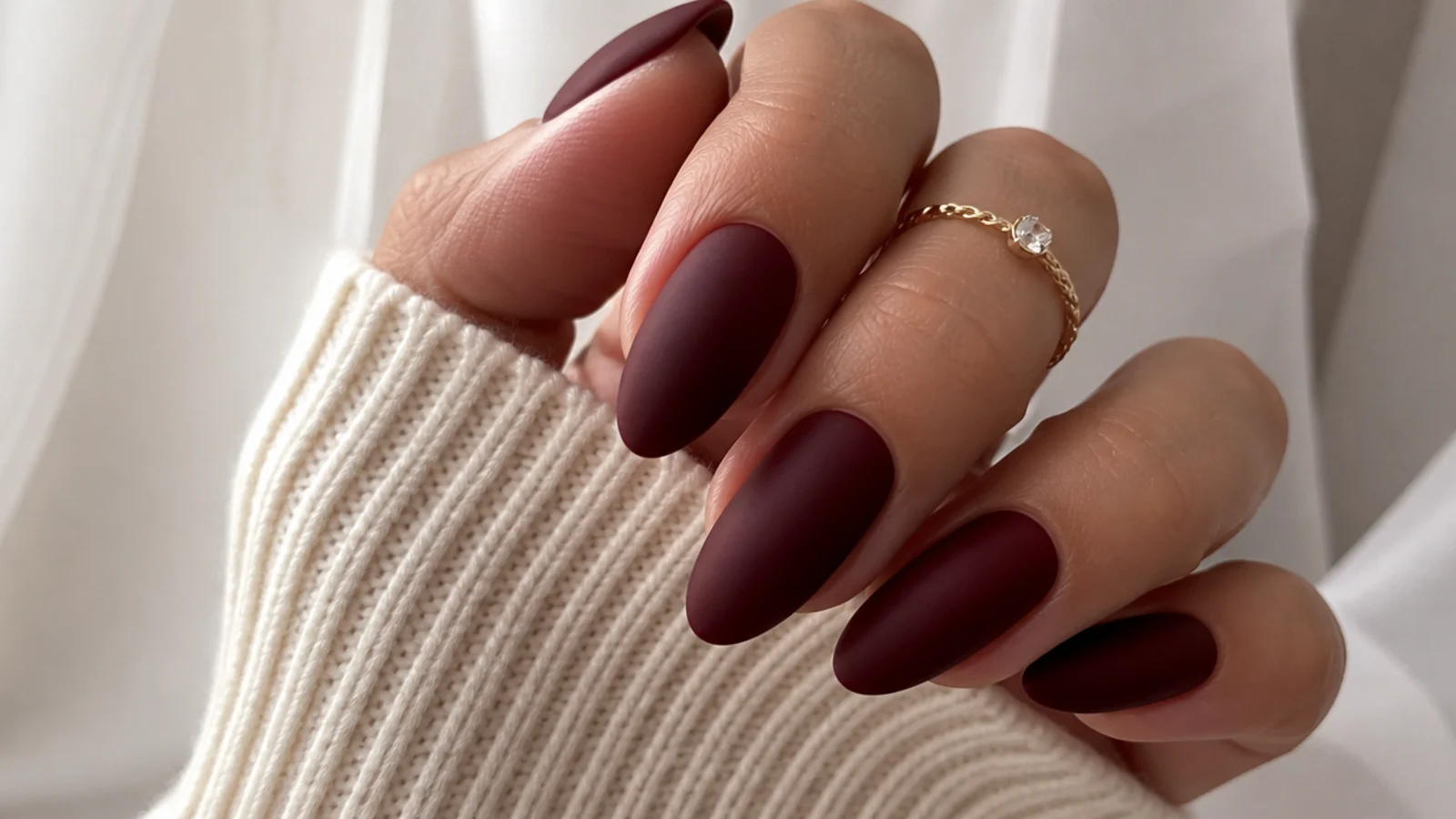 Deep oxblood matte nails on a long almond shape