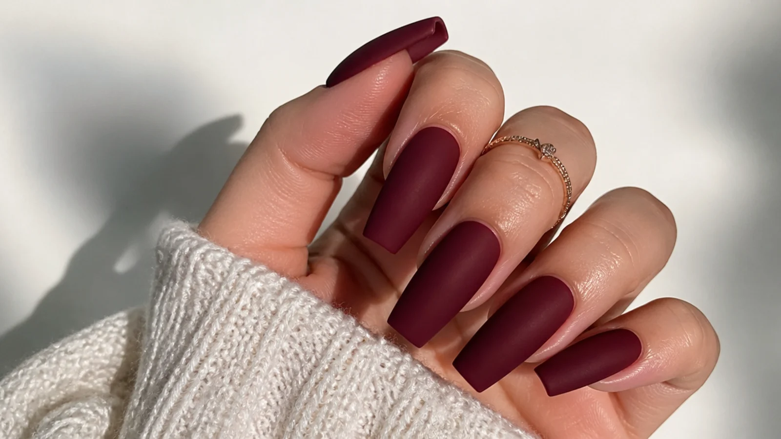 Wine red matte nails with a soft velvet finish on coffin nails