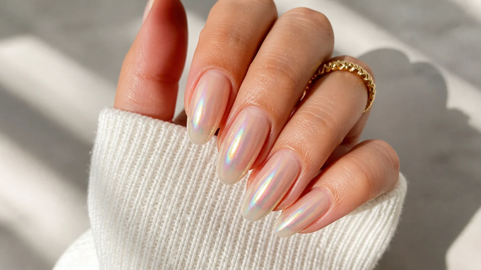 Long almond nails with an iridescent rainbow aura glow shifting across a sheer base