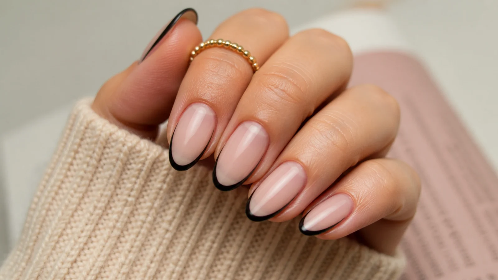 Medium almond nails with a thin black outline leaving the bare nail exposed inside