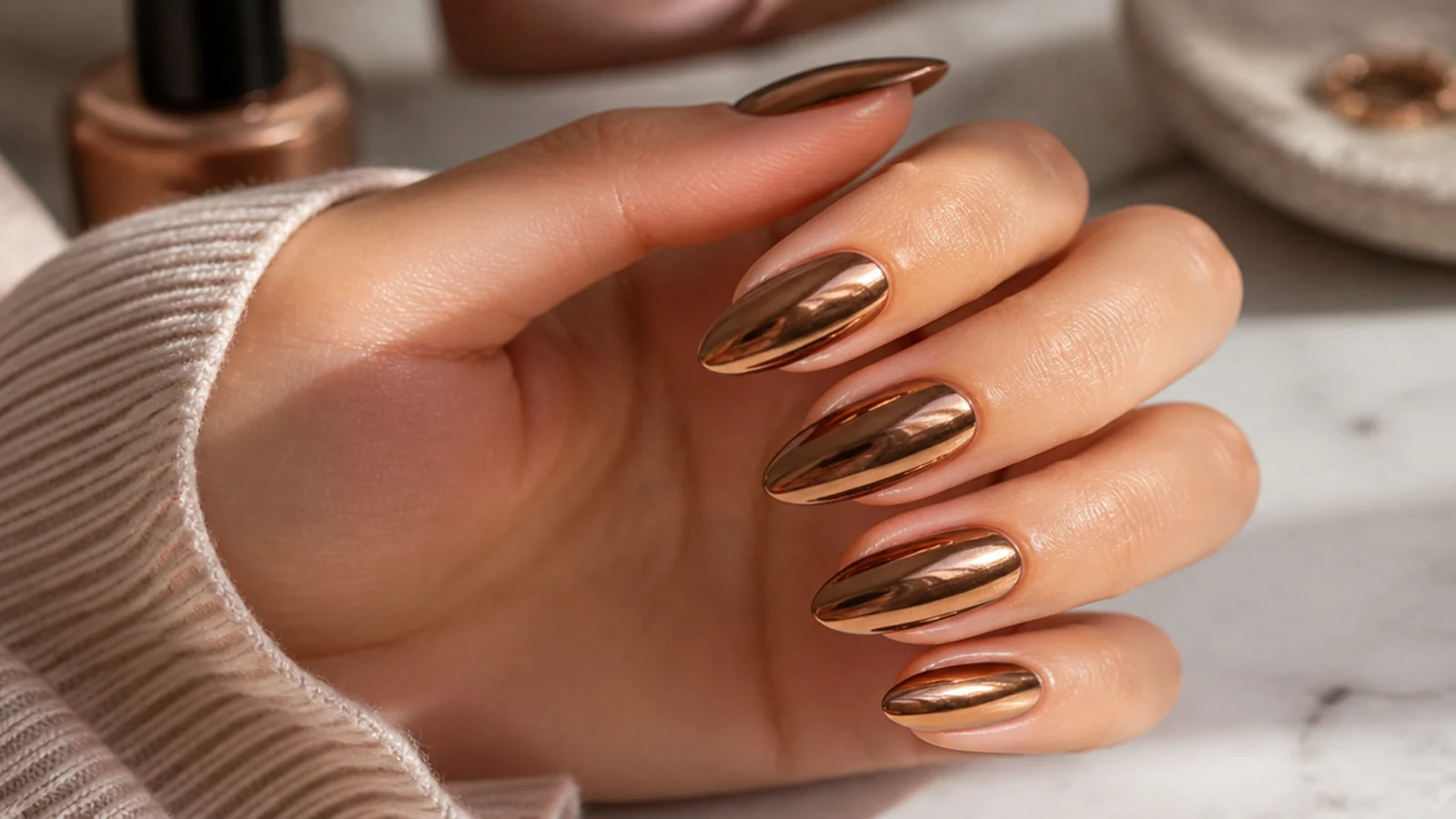 Medium almond nails in metallic brown chrome with a warm bronze mirror finish