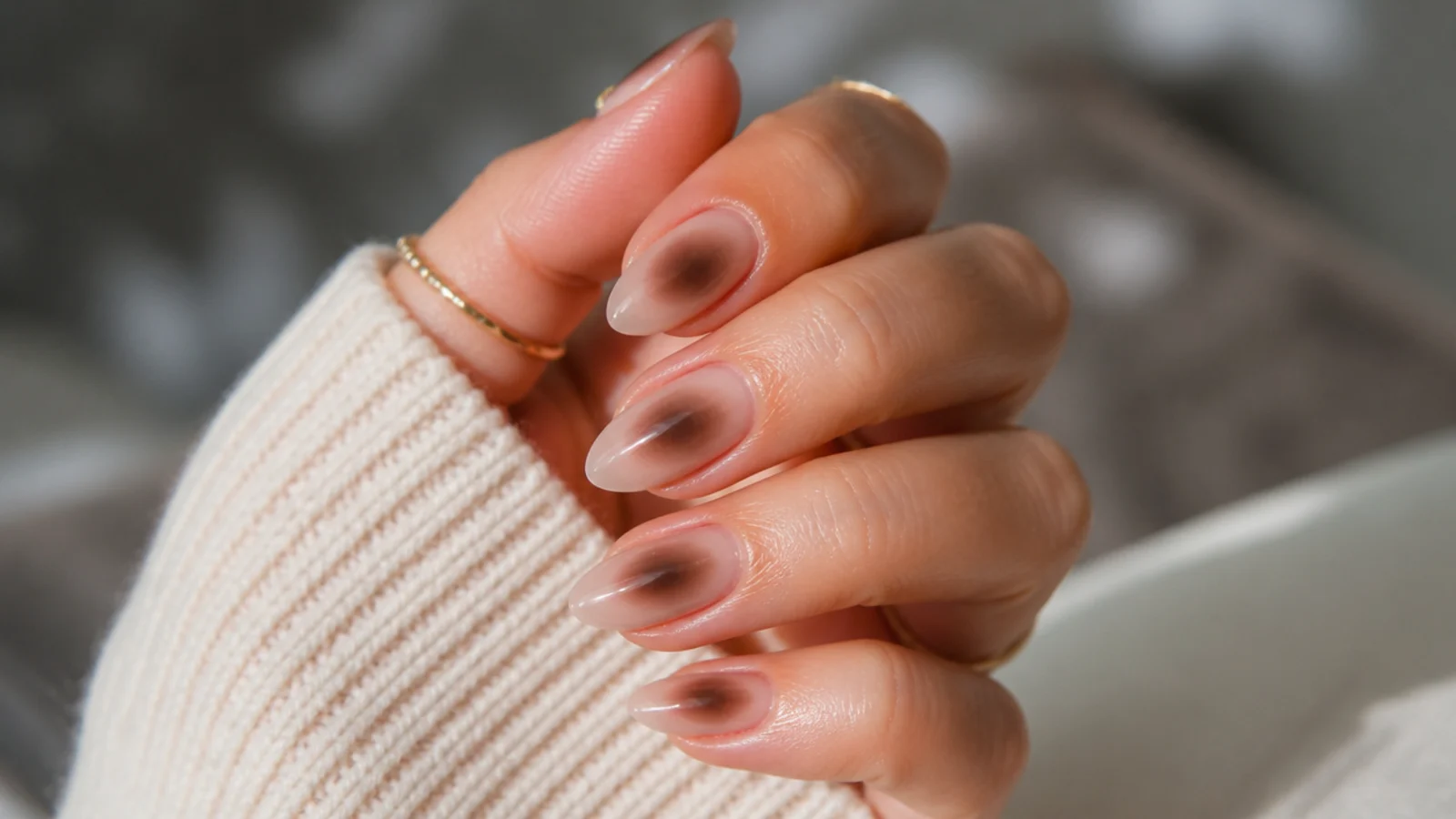 Medium almond nails with a chocolate brown aura halo airbrushed on a nude base