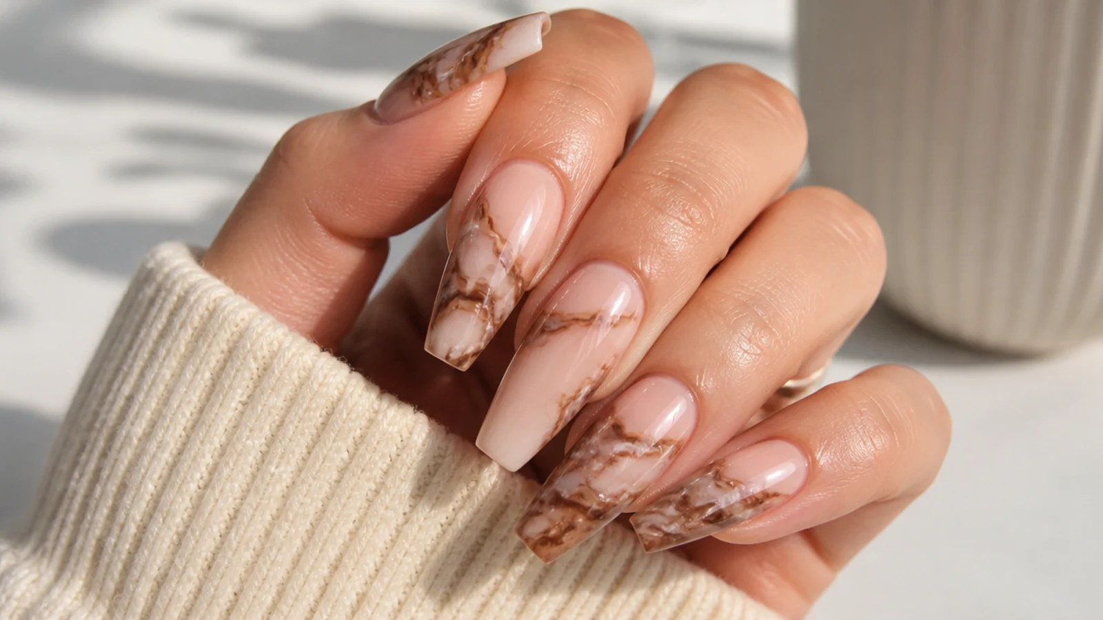 Medium coffin nails with brown and cream marble veining on a nude base