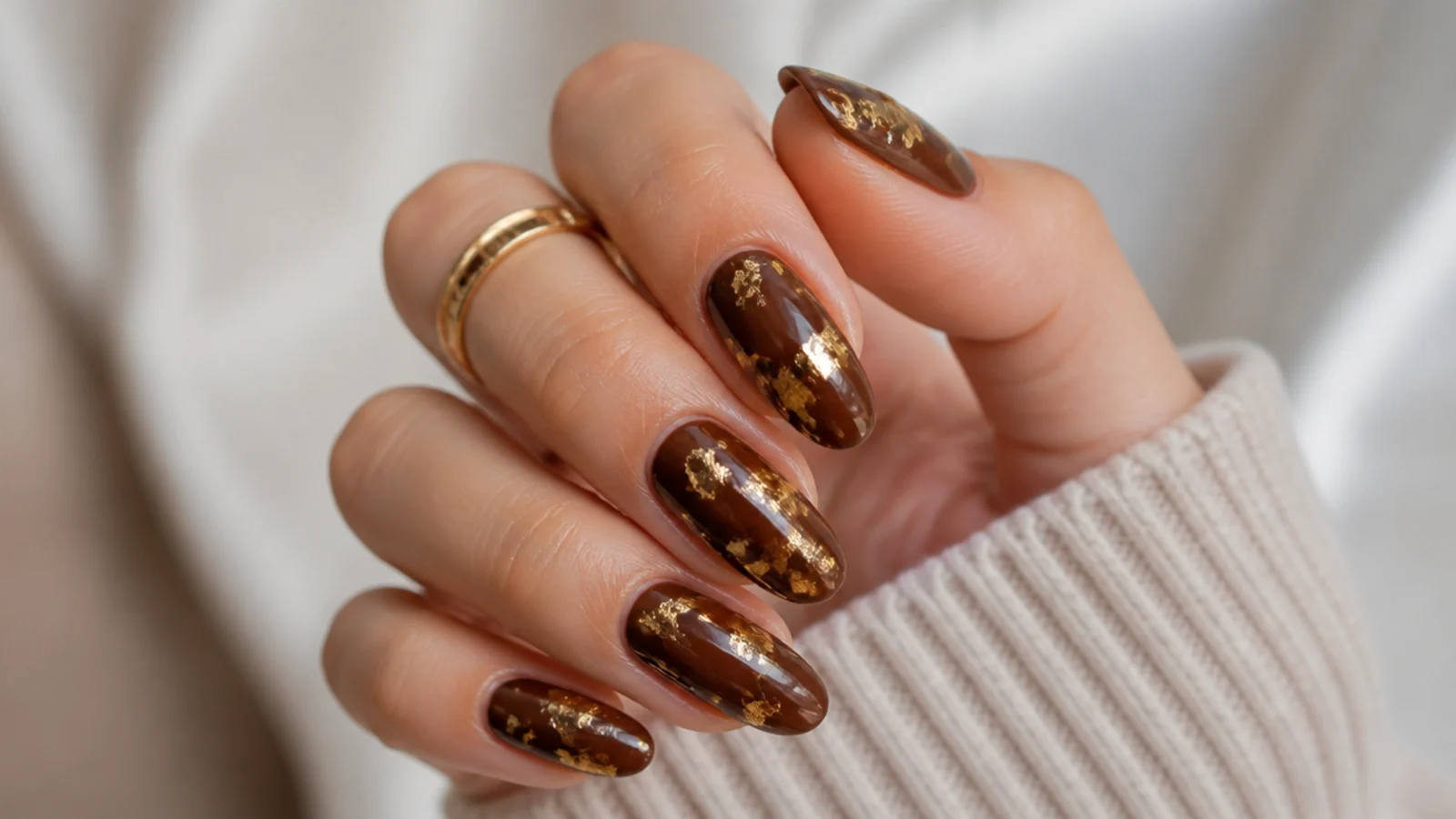 Medium almond nails in chocolate brown with torn gold leaf foil fragments