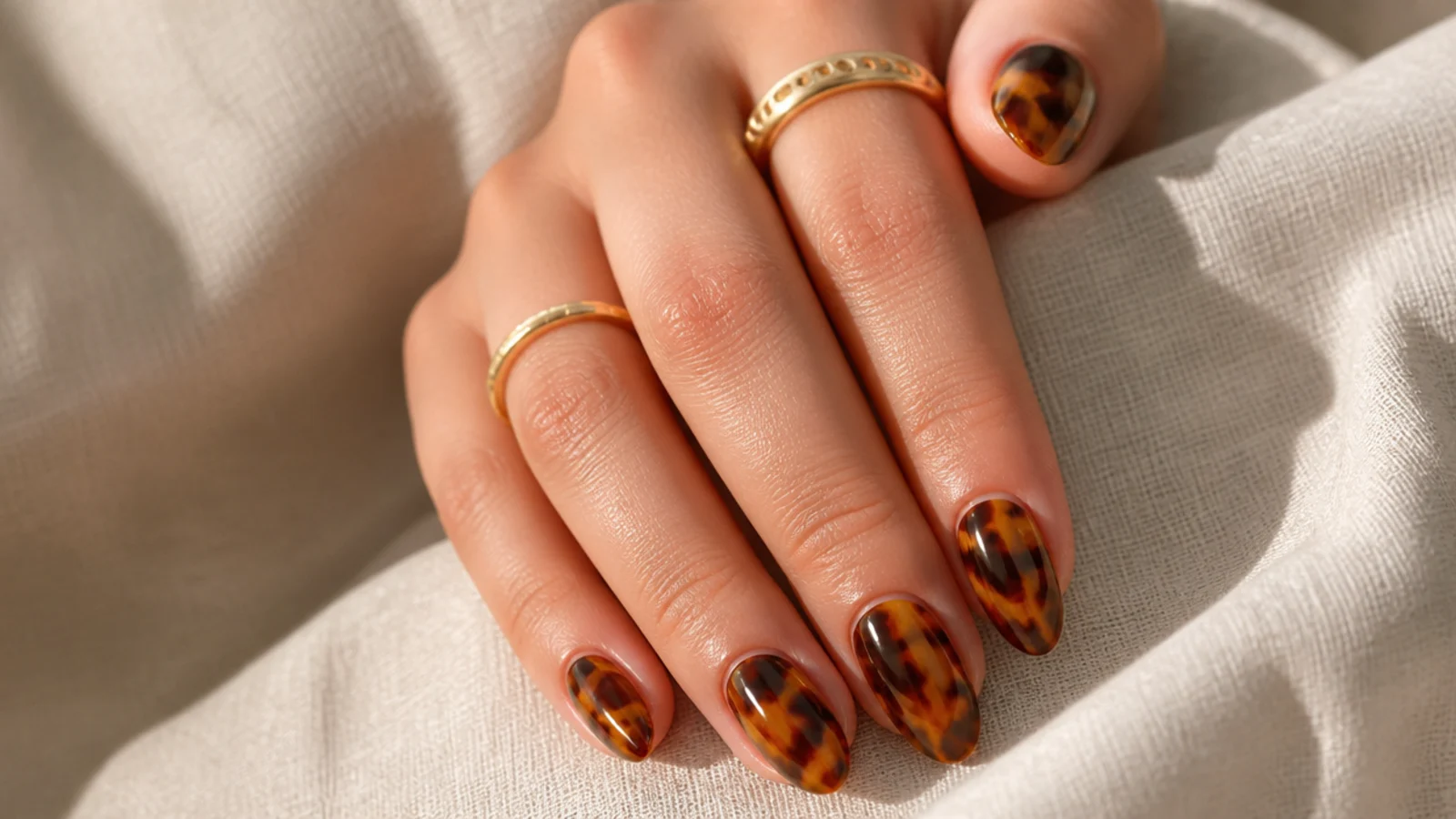 Medium almond nails in amber and dark brown tortoiseshell with mottled marbled patches