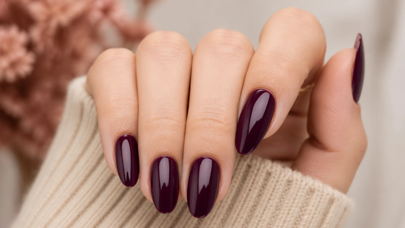Medium almond nails in deep plum wine purple with a glossy jewel-toned finish