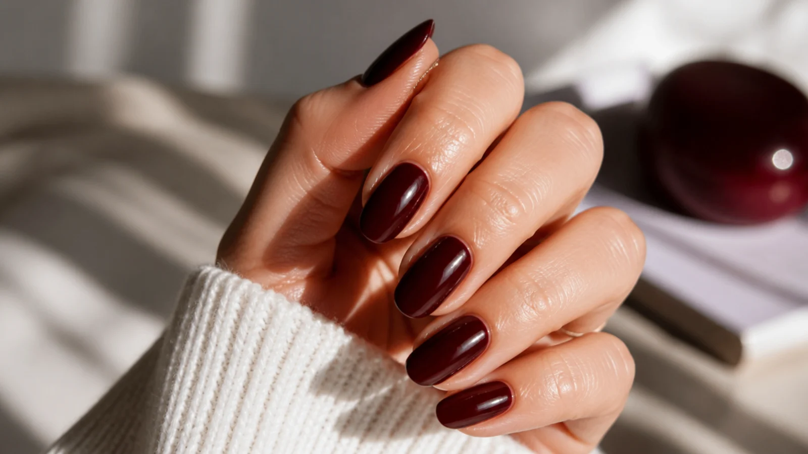 Medium almond nails in deep chocolate cherry brown-red with a glossy layered finish
