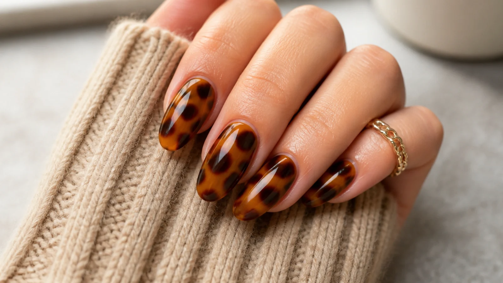 Almond tortoiseshell nails in mottled amber and dark brown over a honey base