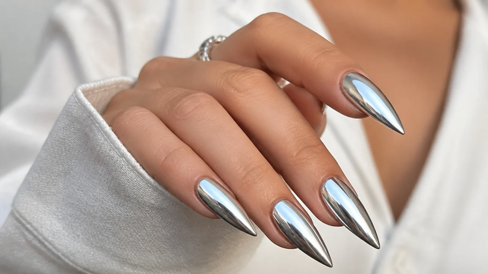 Long silver chrome stiletto nails with a liquid mirror finish and sharp point