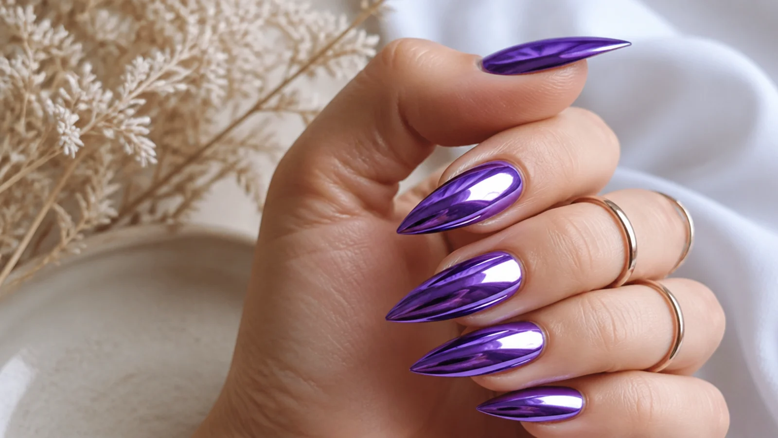 Purple chrome stiletto nails with a cool violet metallic mirror shift