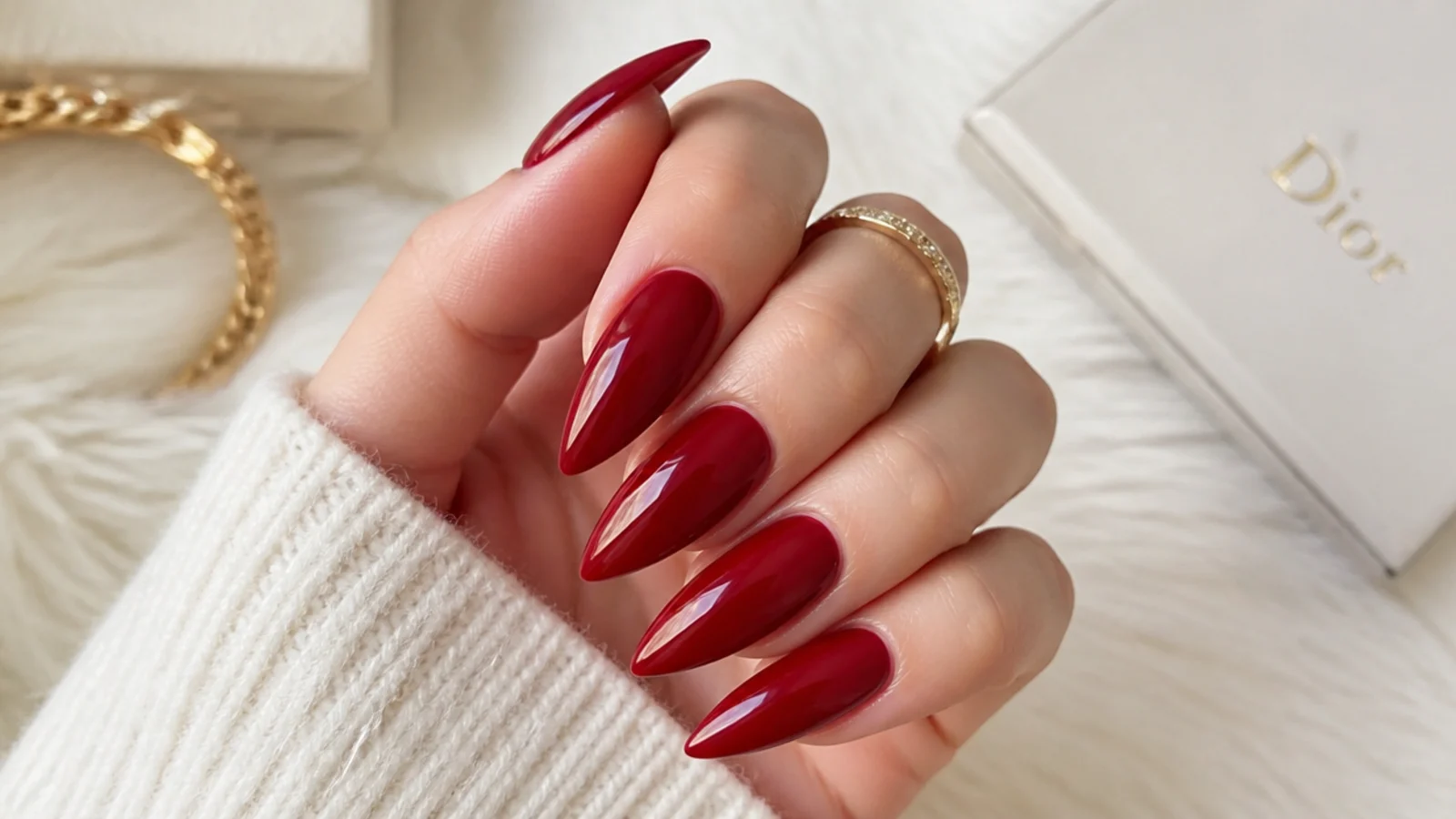 Long cherry red stiletto nails with a deep glossy finish and sharp point