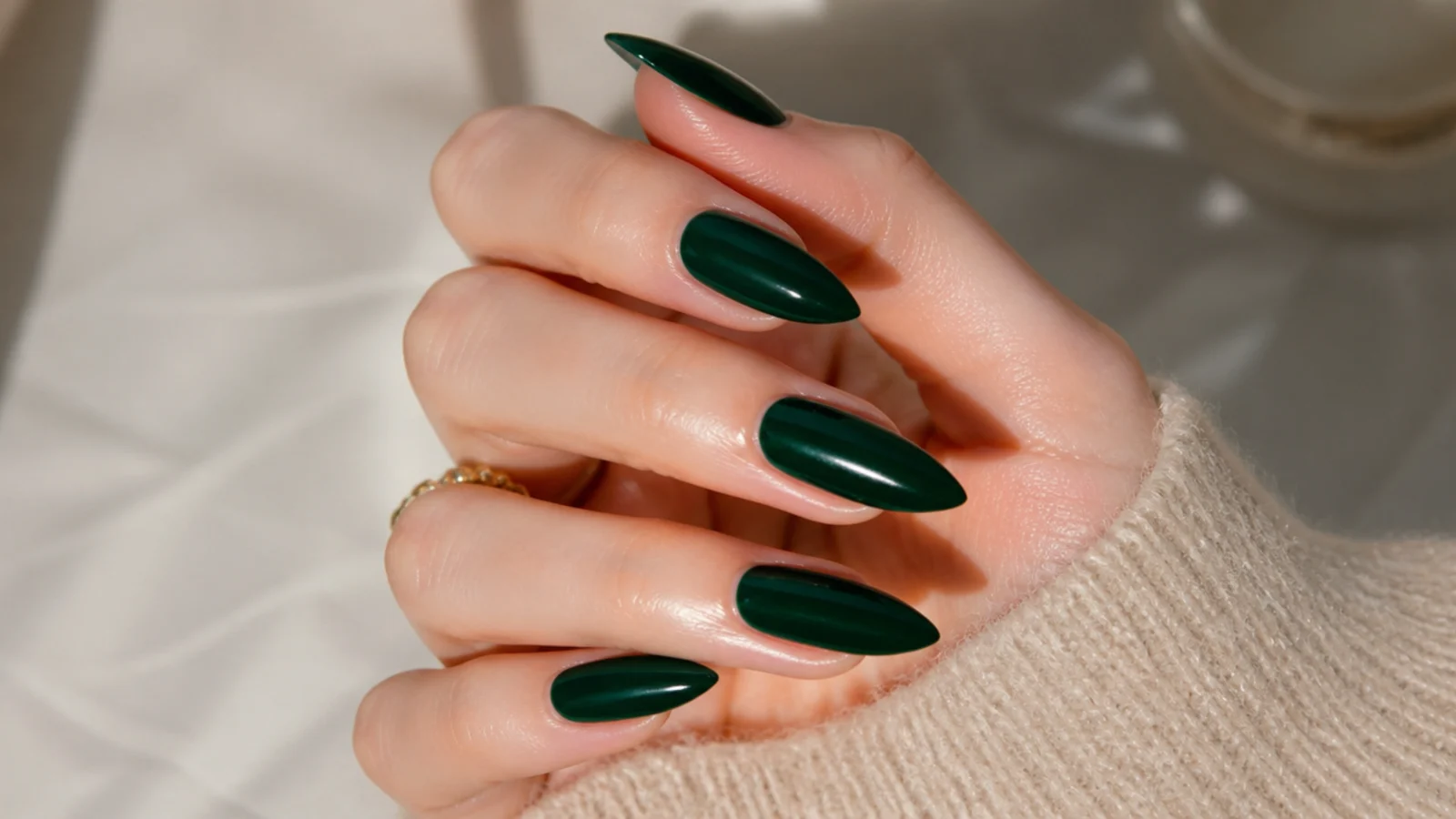 Long emerald green stiletto nails with a jewel-toned glossy finish