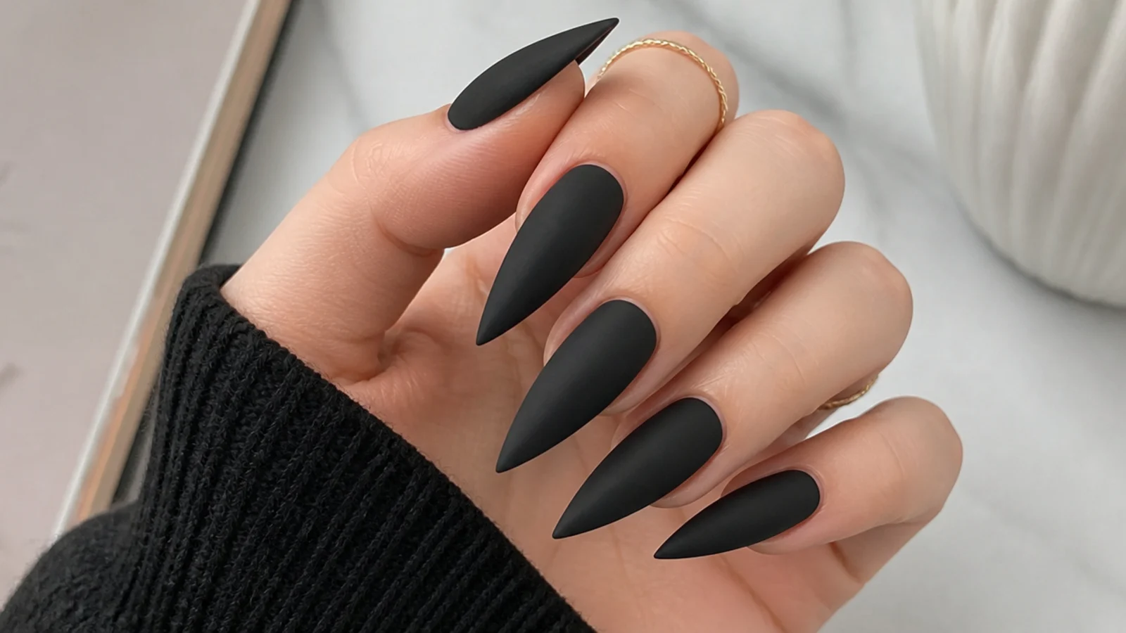 Long matte black stiletto nails with a velvet flat finish and sharp point