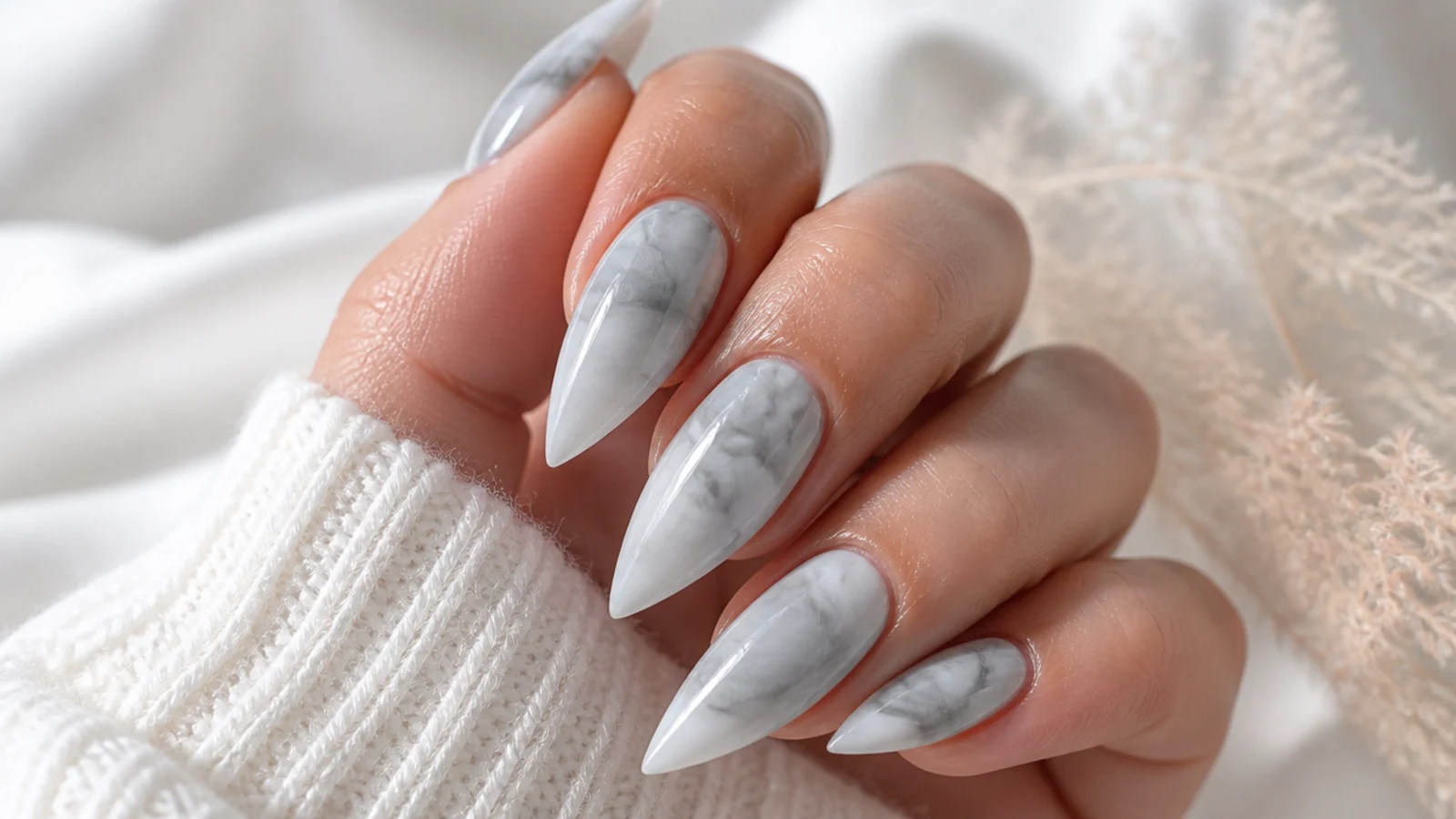 Long stiletto nails with gray and white marble veining under a glossy top coat