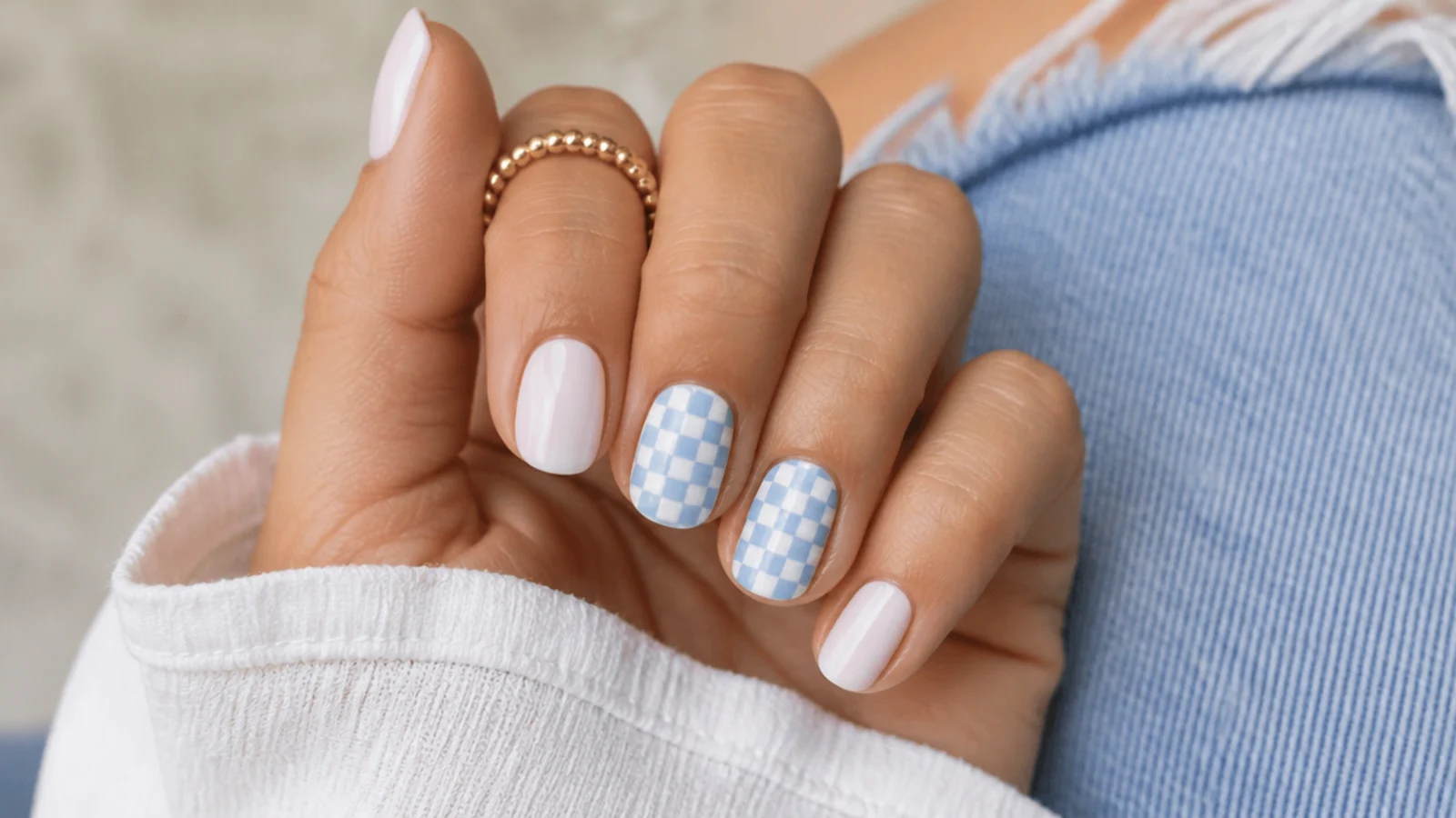 Short summer nails with a pastel blue and white checkerboard pattern on two accent nails
