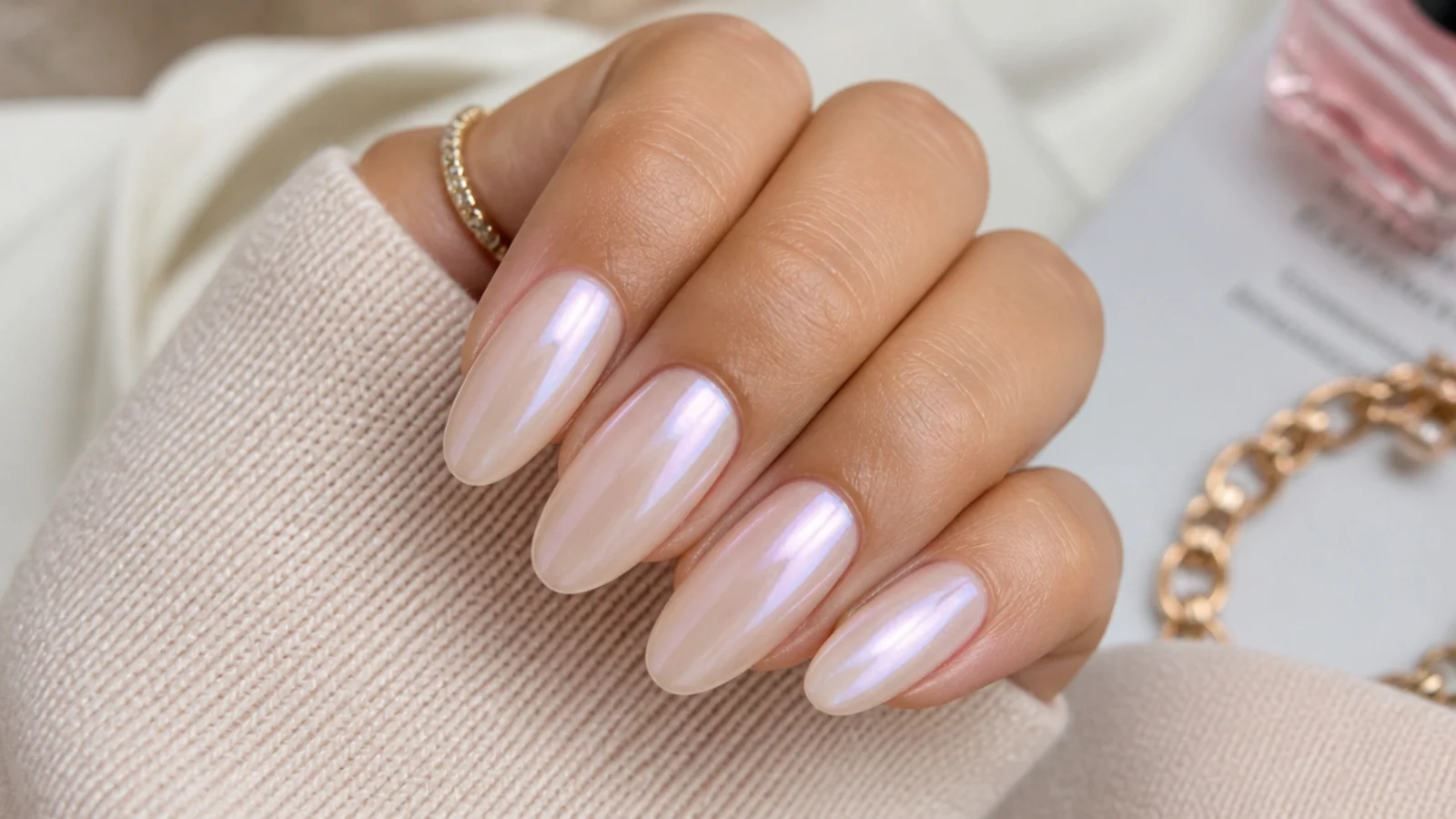 Milky beige acrylic nails with a soft pearl chrome sheen shifting pink and lilac in the light