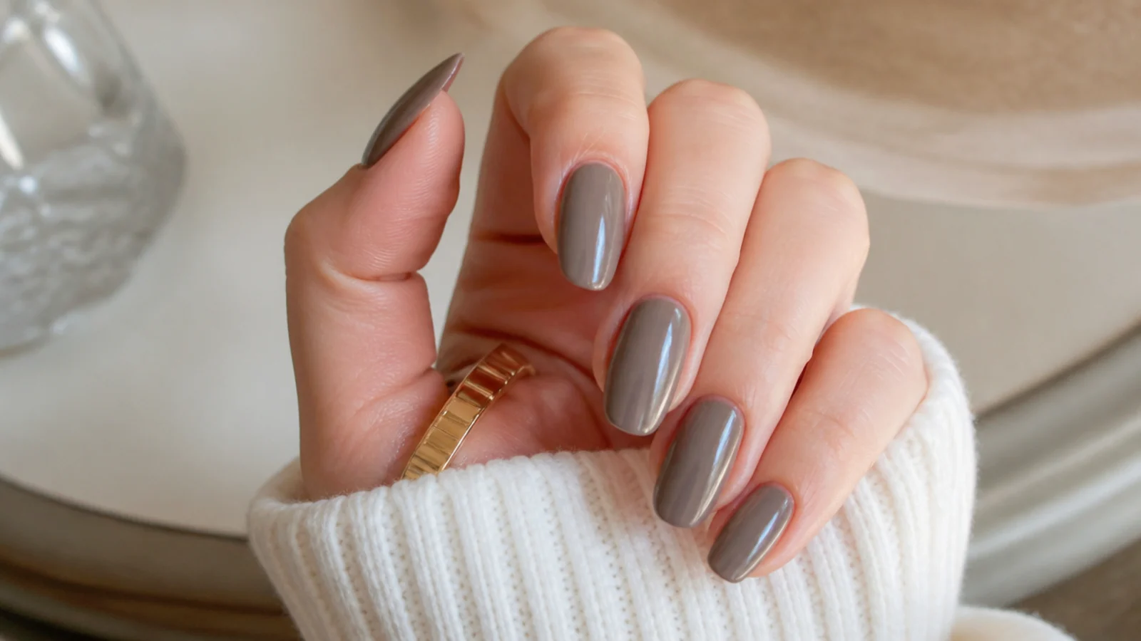 Cool taupe almond nails in a gray-brown opaque shade with a soft rounded tip