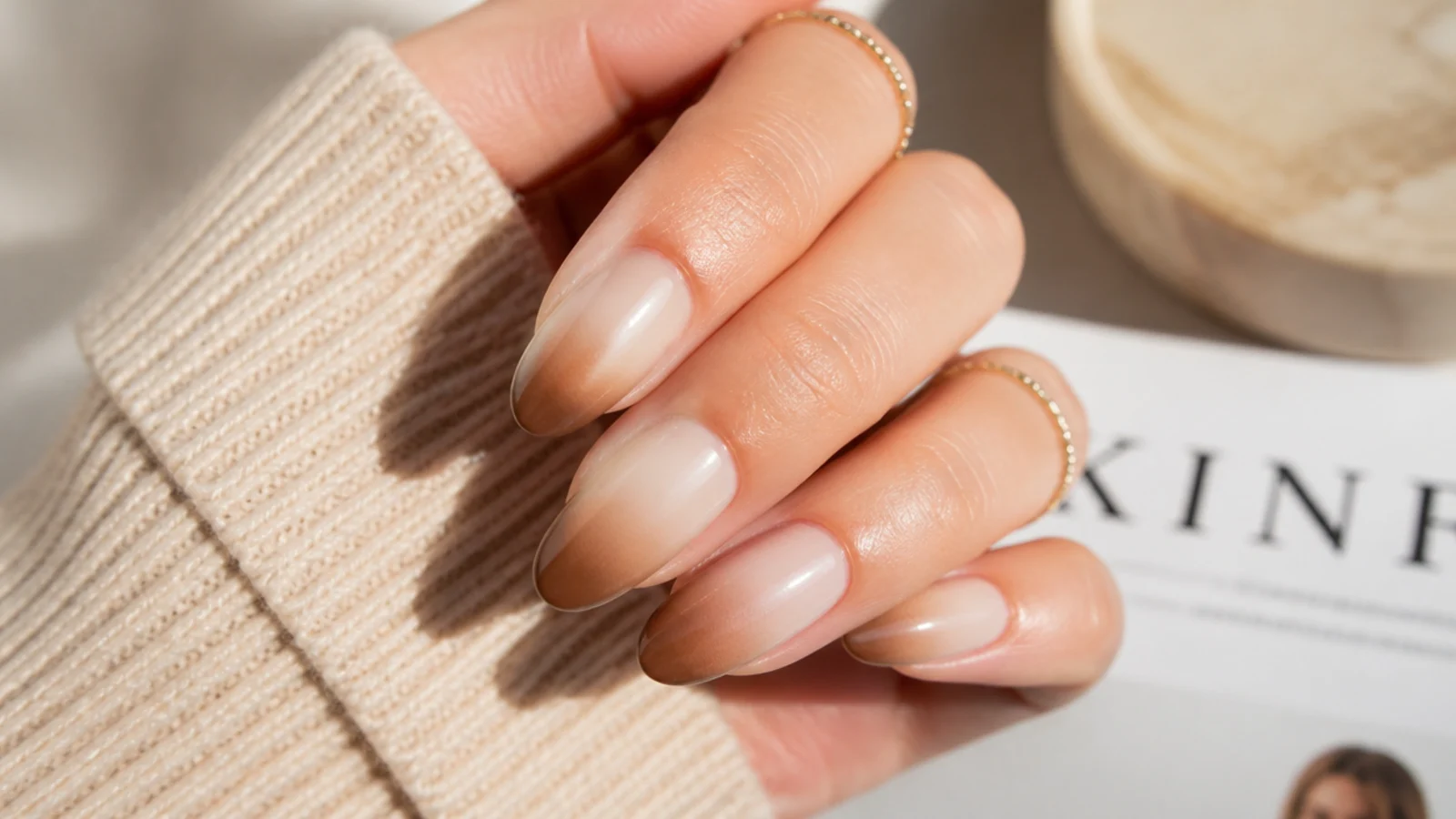 Almond nails with a soft gradient fading from beige at the cuticle to brown at the tip