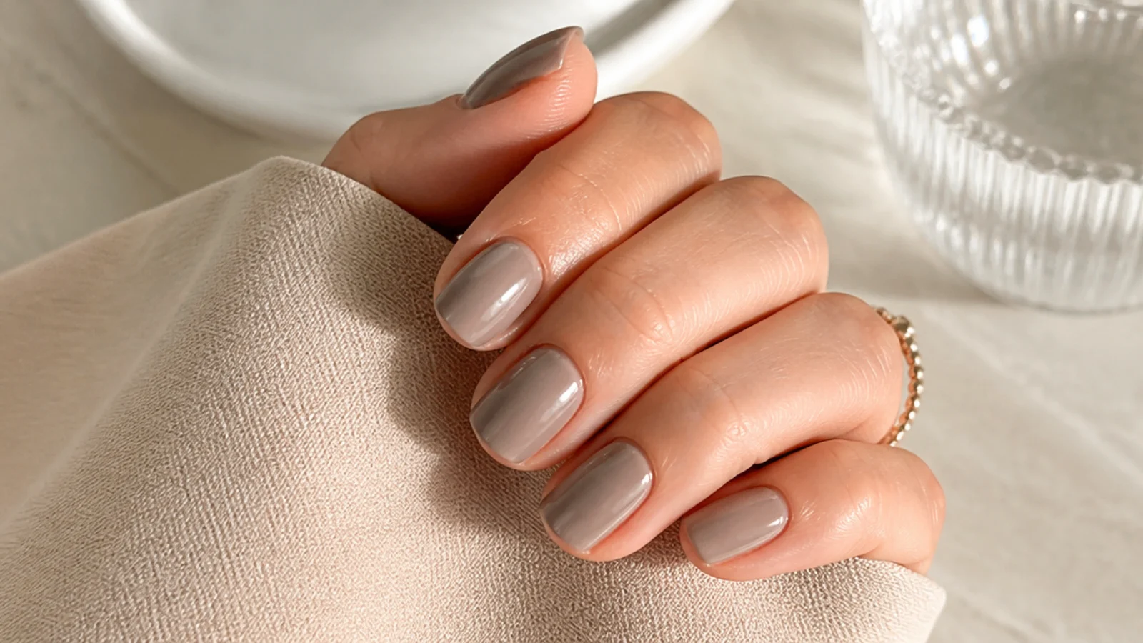 Short milky taupe nails in a soft greige beige with a satin gloss finish