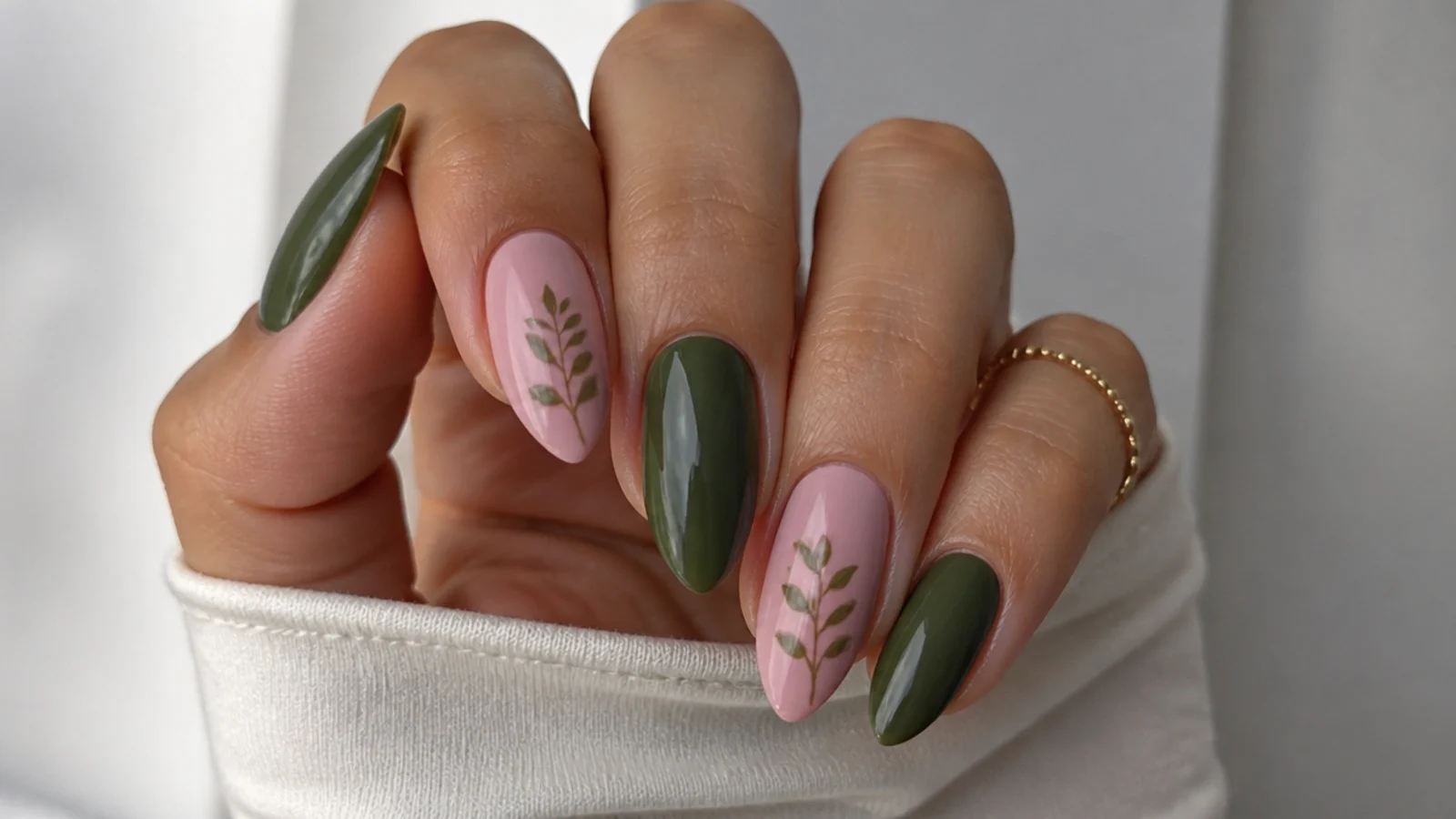 Dark olive green and soft pink nails alternating on almond shape