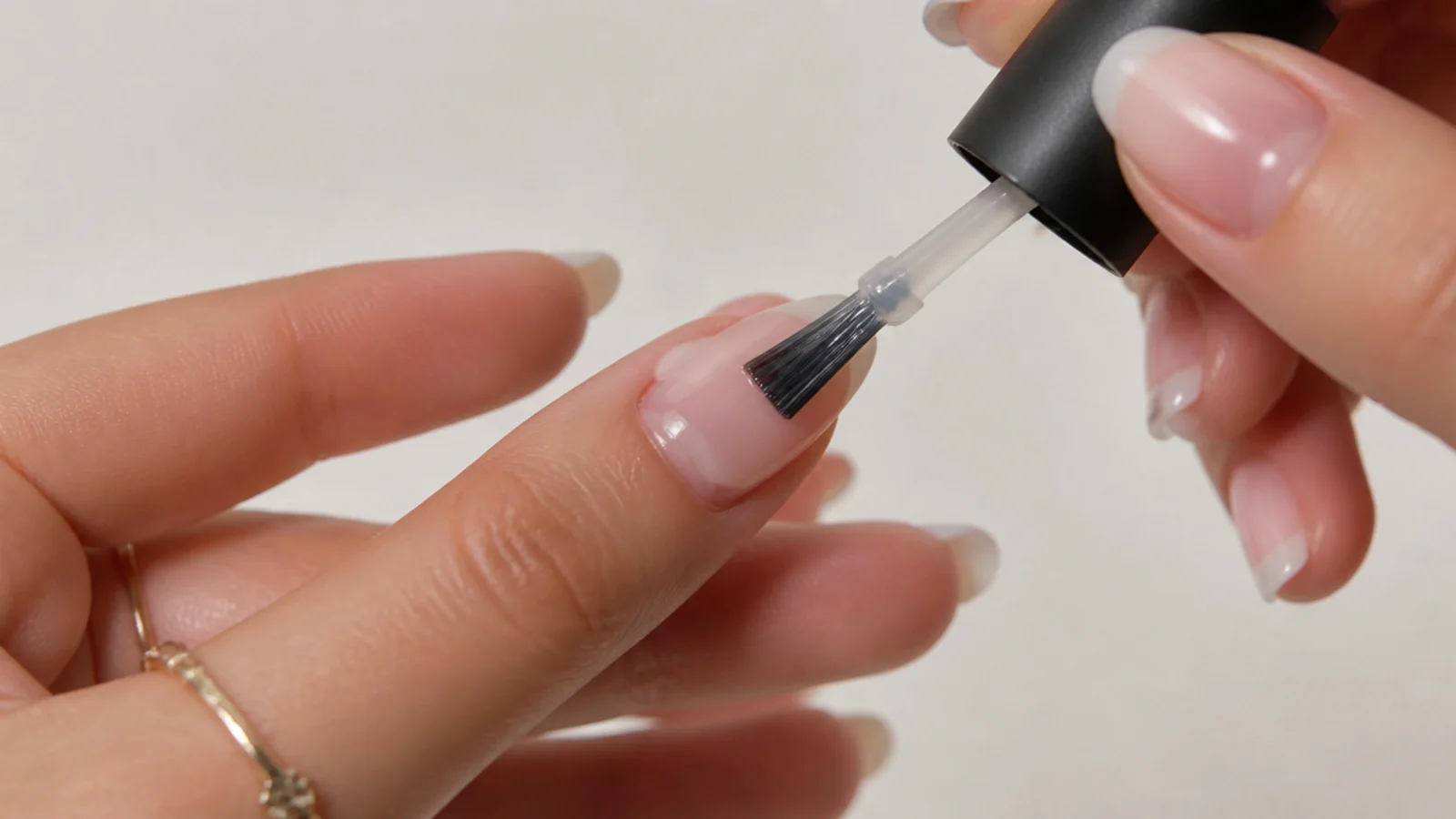 A thin gel base coat being applied to a prepped nail