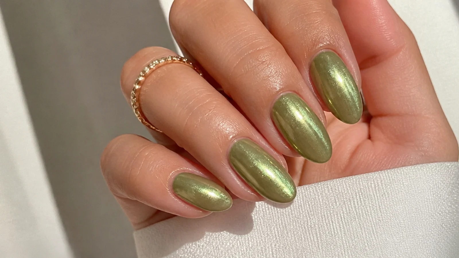 Light olive green chrome nails with a glazed metallic sheen