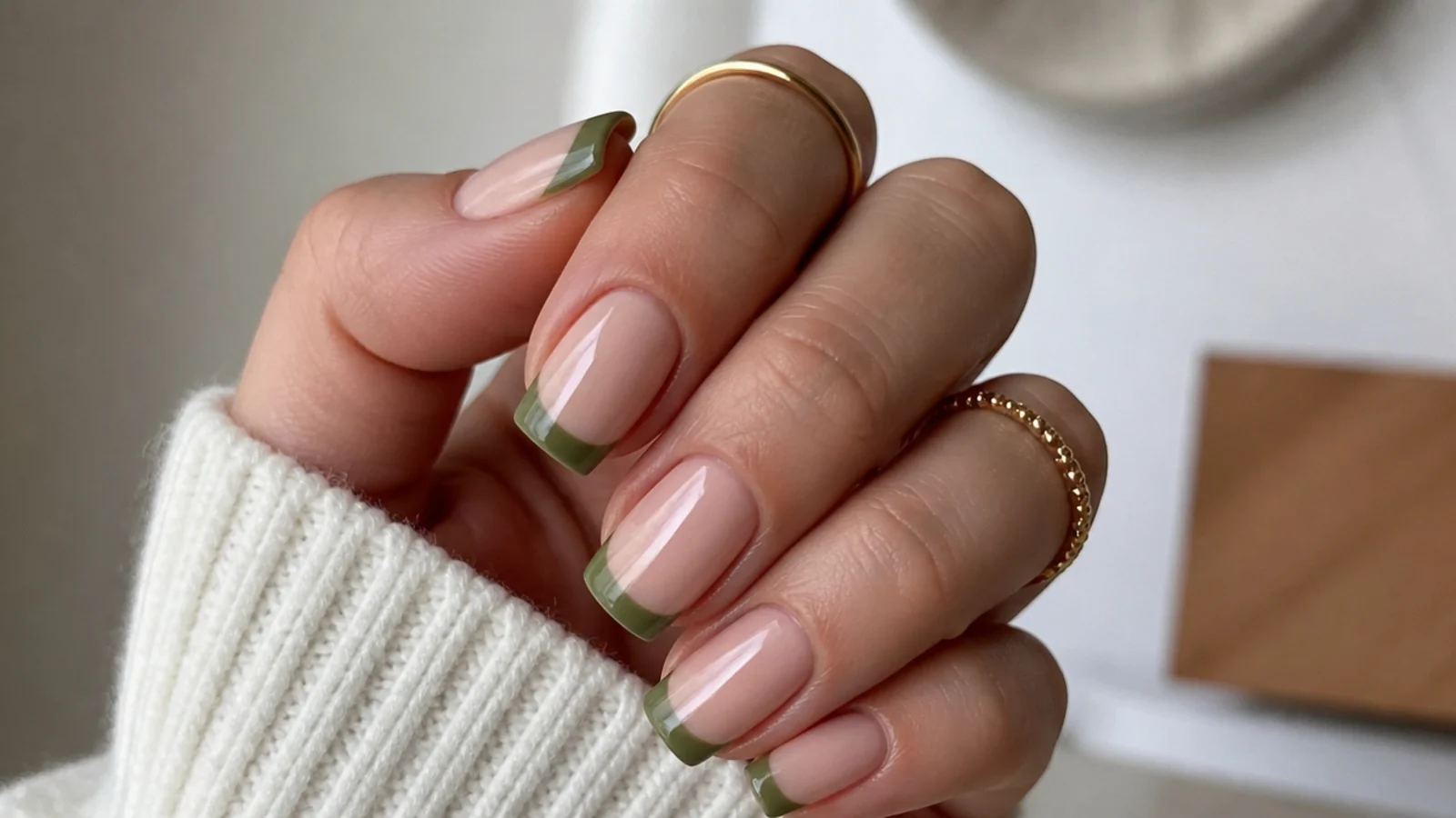 Nude nails with light olive green french tips on a square shape
