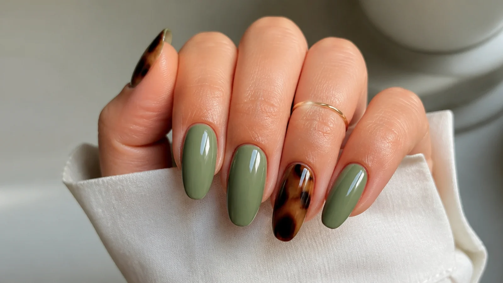 Light olive green nails with brown tortoiseshell accent detail