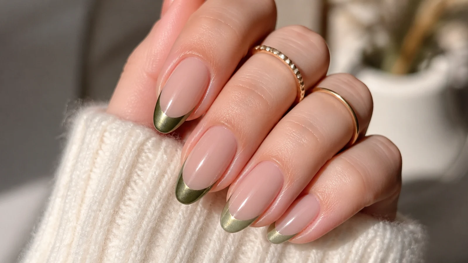 Nude nails with light olive chrome french tips on an almond shape
