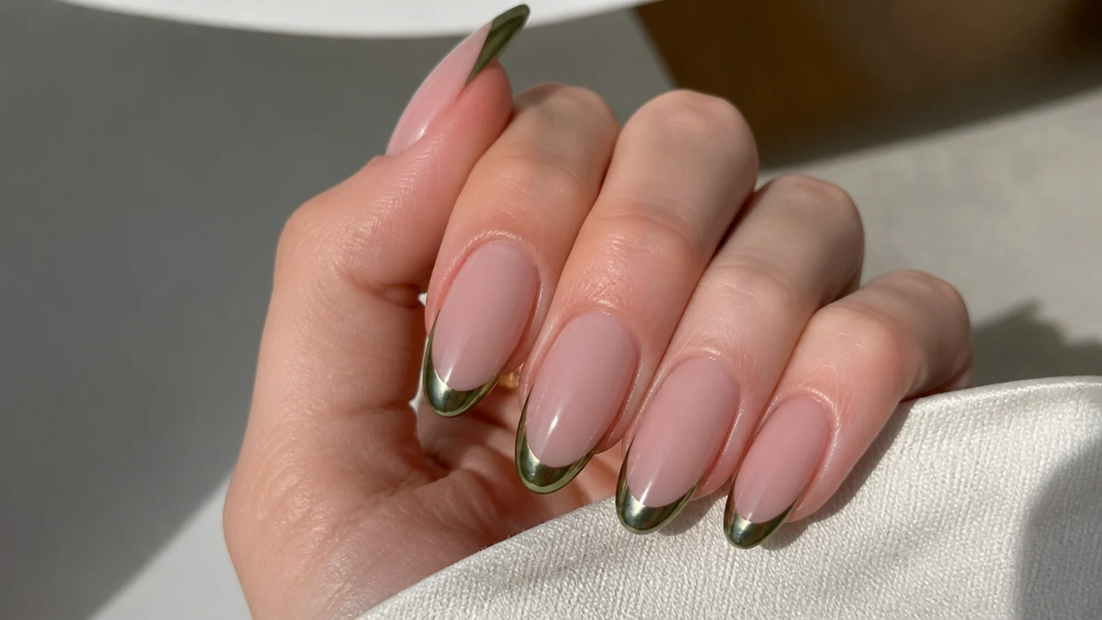 Nude acrylic nails with an olive chrome mirror french tip