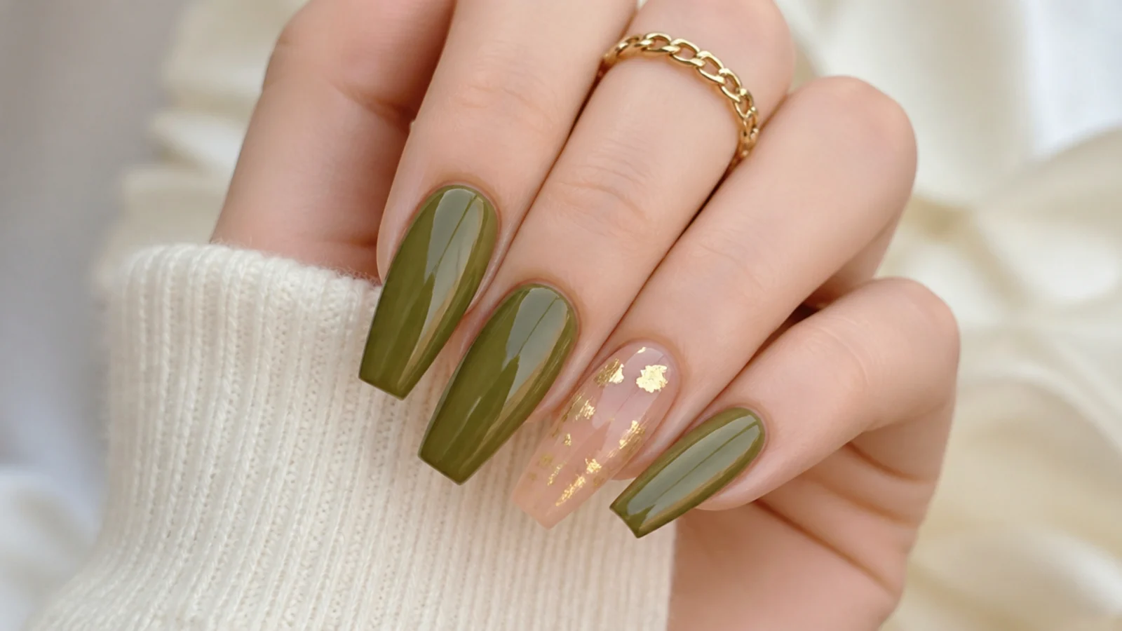 Olive green acrylic nails with gold leaf flakes on an accent nail