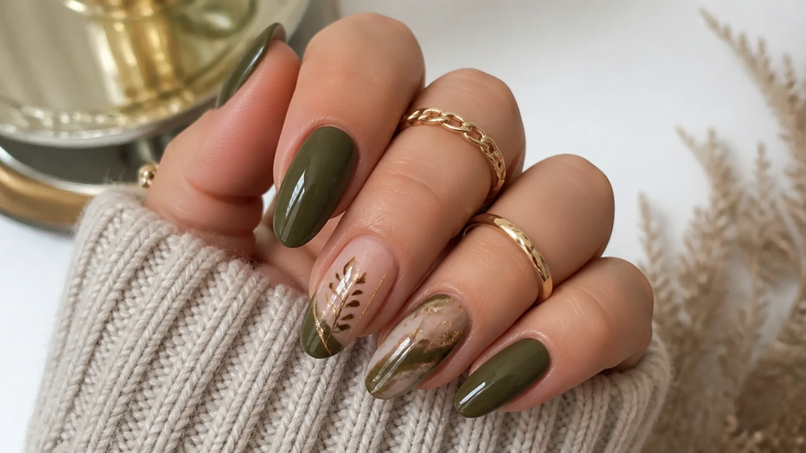 Olive green nails styled for fall with warm sweater and gold jewelry