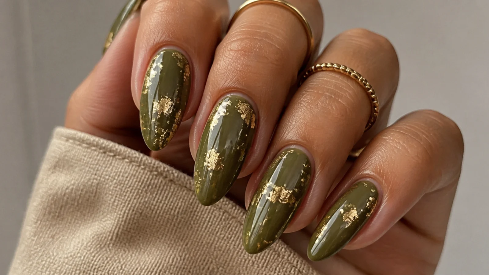 Warm olive almond nails with torn gold foil flakes