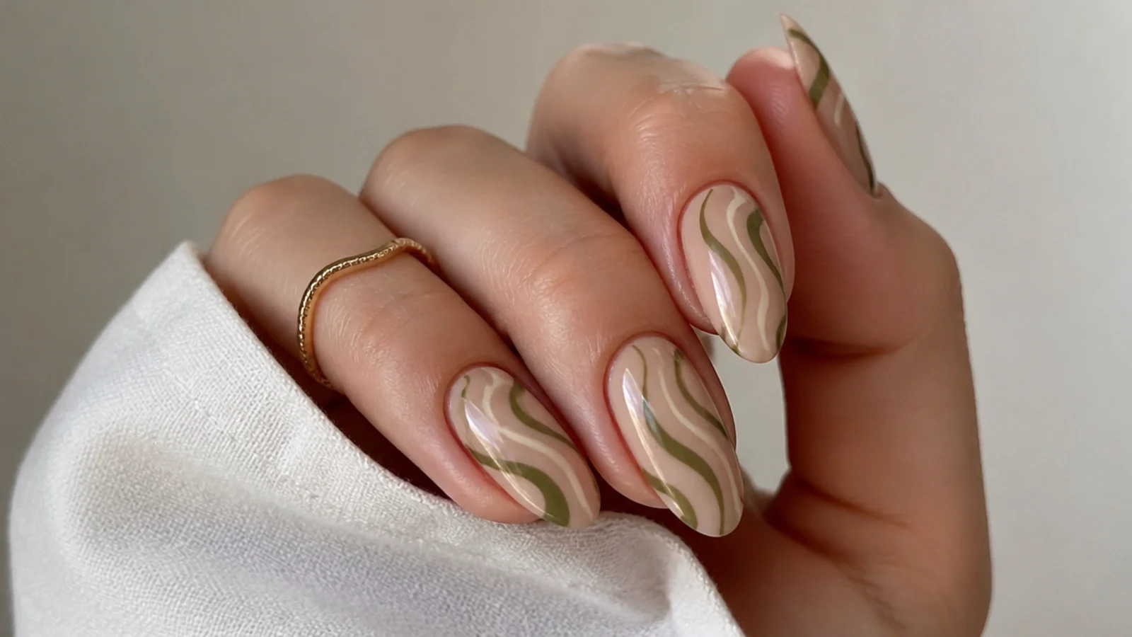 Nude almond nails with warm olive abstract line art
