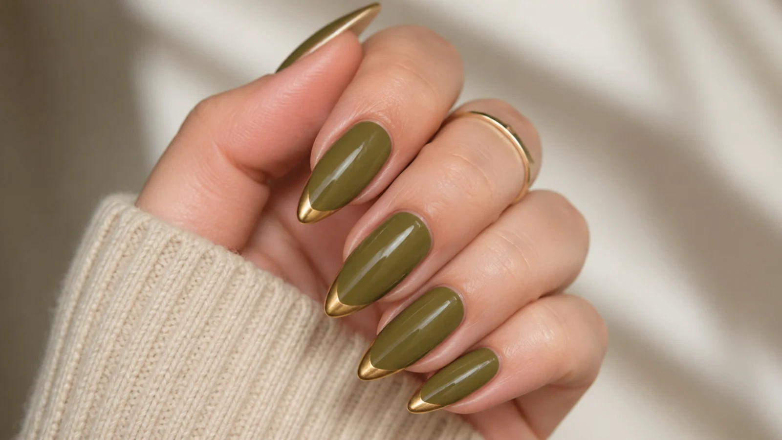 Warm olive almond nails with metallic gold painted tips