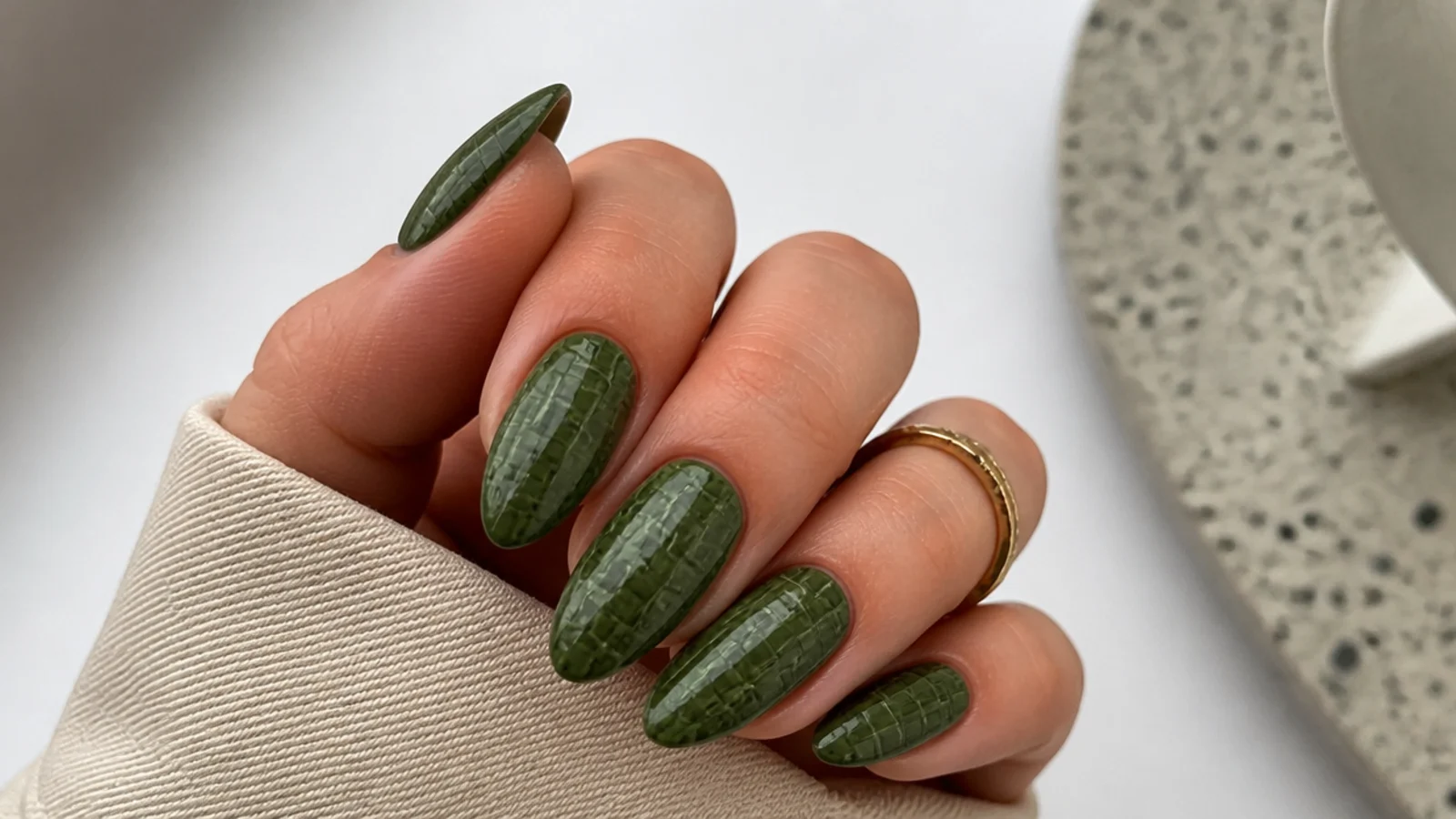 Warm olive green almond nails with a croc-print texture