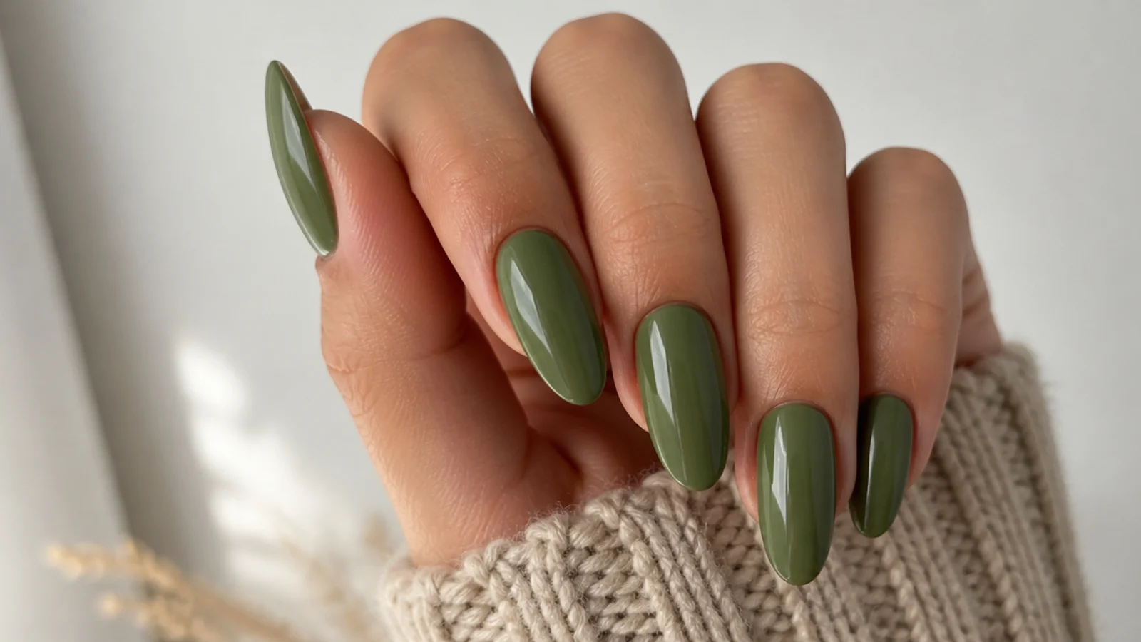 Glossy warm olive green almond nails on a tan skin tone
