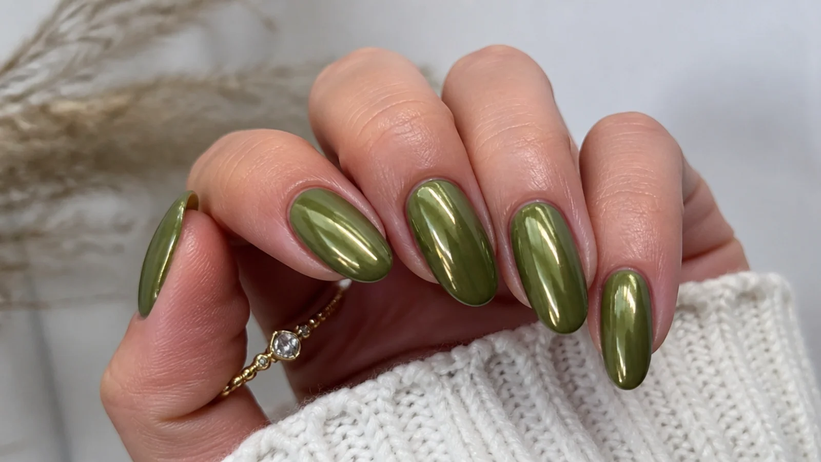 Olive green nails with a warm gold chrome mirror finish on almond shape