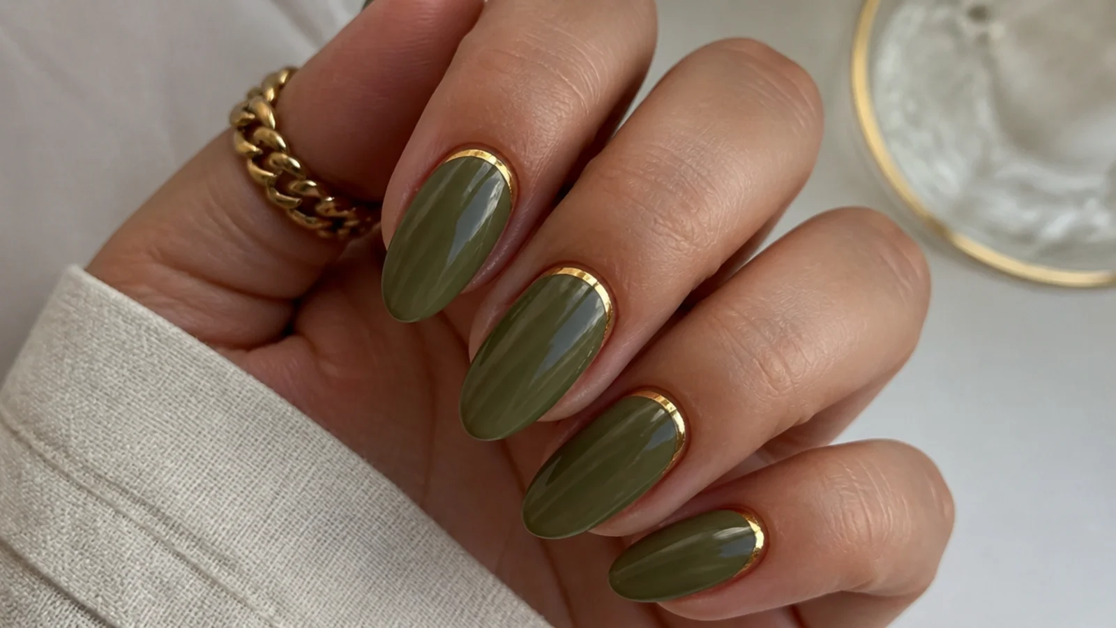 Olive green nails with a thin gold half-moon cuticle line
