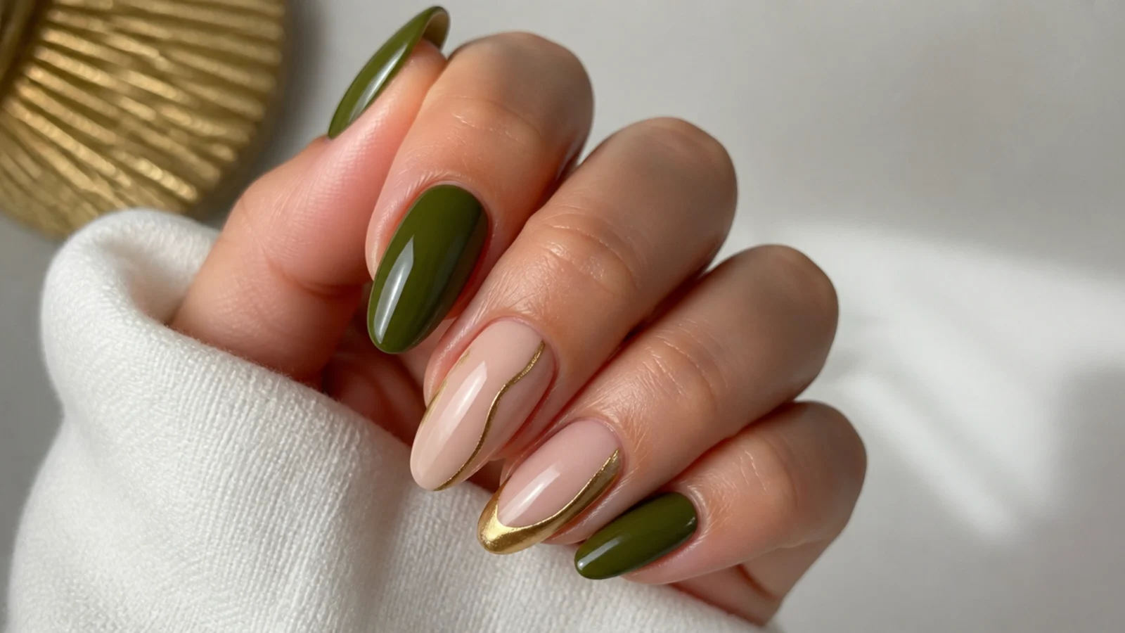 A well-sealed olive green and gold gel manicure with cuticle oil