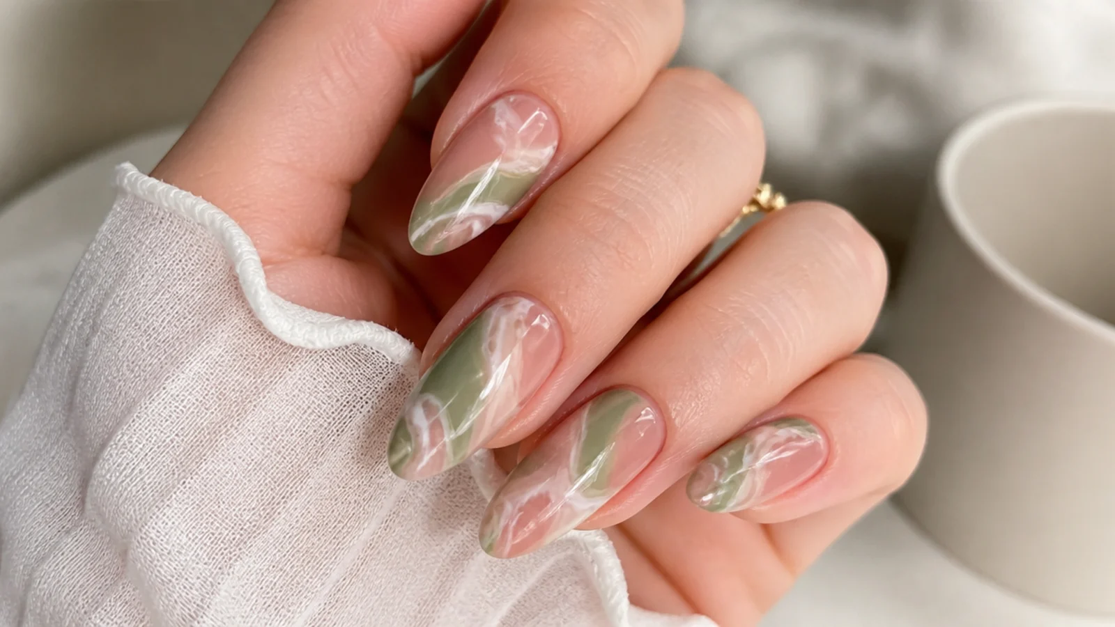Soft olive green and pink marble swirl nails with hazy veining