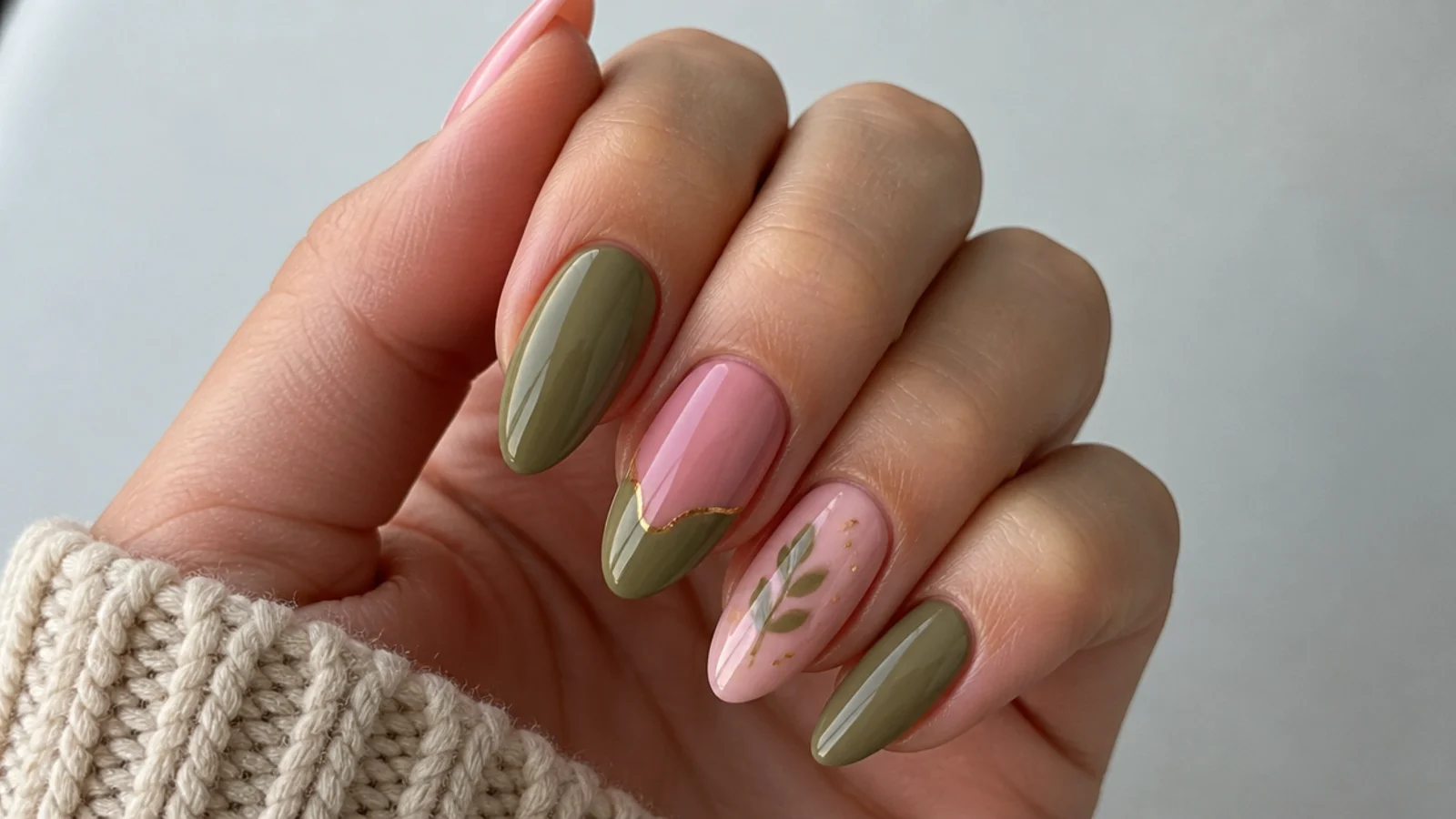 Muted olive green and soft pink nails on an almond shape with a glossy finish