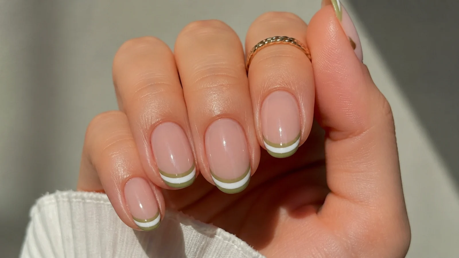 Double french tip nails with a white line under an olive green tip