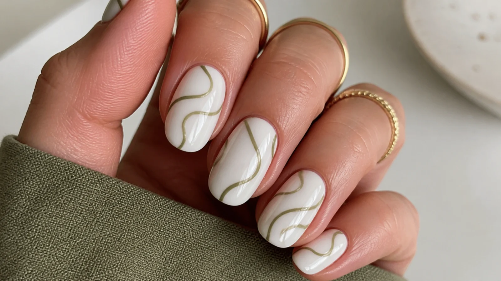 White nails with fine olive green abstract line-art squiggles