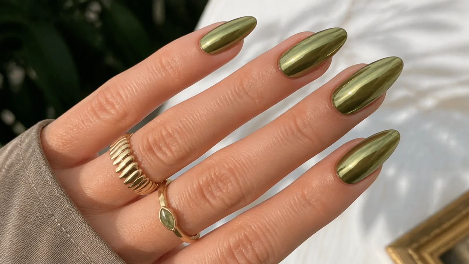 Long olive green chrome nails on an elongated almond shape